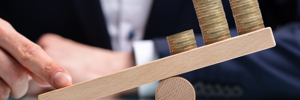 Close-up,Of,A,Businessperson,Balancing,Increasing,Stacked,Coins,With,Finger