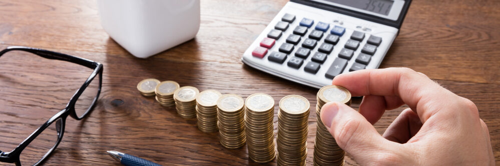 Close-up,Of,A,Person,Hand,Calculating,On,Wooden,Desk,In