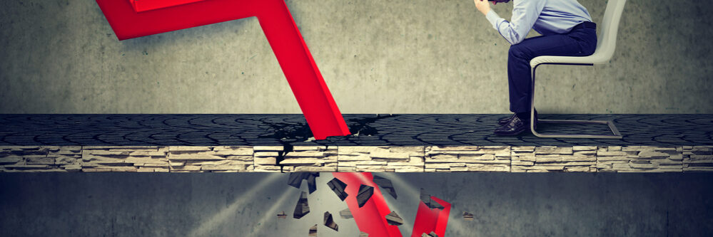 Depressed,Business,Man,Looking,Down,At,The,Falling,Red,Arrow
